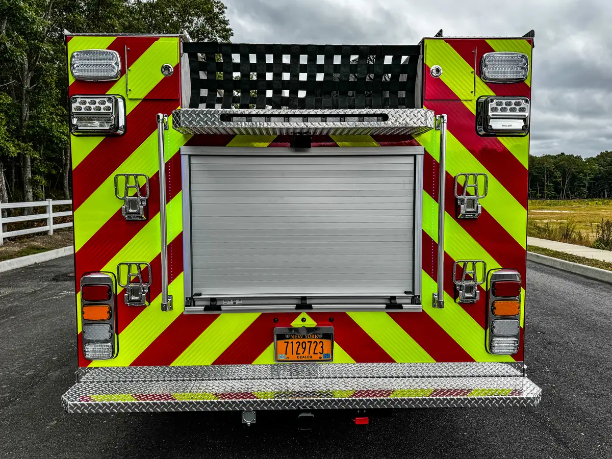 Rear-left corner close-up showing taillight stack and warning striping.